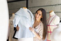Jeune créateur de mode ajustant des vêtements sur le modèle de couturière — Photo de stock