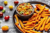 Homemade sweet potato fries and bowl of tomato basil dip — Stock Photo