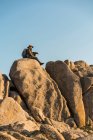 Italia, Sardegna, escursionista con cappello e zaino appoggiato su una roccia — Foto stock