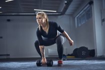 Жінка у спортзалі робить гімнастичні вправи. — стокове фото