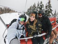Italy, Modena, Cimone, portrait of happy friends in a ski lift — Stock Photo