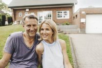 Ritratto di coppia matura sorridente seduta in giardino di casa — Foto stock