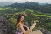 Laos, Vang Vieng, young woman on top of rocks taking a selfie — Stock Photo