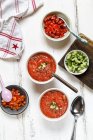 Two bowls of Gazpacho and bowls of ingredients — Stock Photo