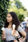 Due amiche che mangiano gelato in città — Foto stock
