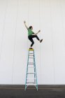Akrobat balanciert auf Leiter — Stockfoto