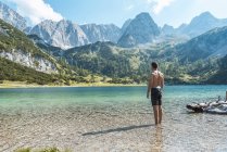 Österreich, Tirol, Junger Mann am Seebensee steht knöcheltief im Wasser — Stockfoto