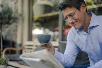 Homme d'affaires mature assis dans un café, buvant du café — Photo de stock