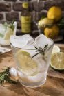 Bicchiere di Gin Tonic con limone, rosmarino e ghiaccio — Foto stock