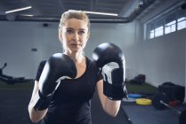 Portrait de femme pratiquant la boxe au gymnase — Photo de stock