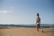Стильна дівчина-підліток, що йде на піщаному пляжі — стокове фото