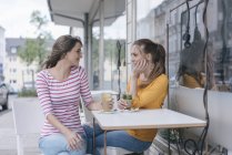 Дві подруги зустрічі в кафе і говорити — стокове фото