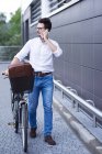 Businessman on the phone pushing his bicycle — Stock Photo