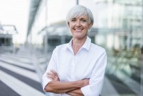 Portrait of smiling senior businesswoman standing in city — Stock Photo