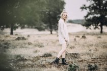 Giovane donna bionda con stivali e pullover oversize, lunghezza intera — Foto stock