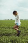 Junge Frau geht auf einer grünen Wiese — Stockfoto