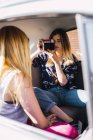 Фотограф фотографирует девушку, сидящую в машине — стоковое фото