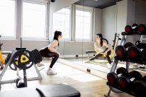 Woman exercising in gym looking in mirror — Stock Photo
