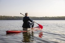 Зворотній вигляд бізнесмена веслування на озері — стокове фото