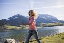 Австрия, Тироль, Вальхзее, улыбающаяся женщина, гуляющая по озеру — стоковое фото