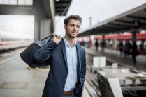 Smiling businessman with bag at the platform — Stock Photo