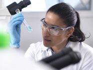 Biotechnology Research, científica femenina que mezcla una fórmula química - foto de stock