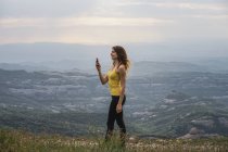 Spagna, Barcellona, giovane donna che si fa selfie sulla Montagna Montcau — Foto stock