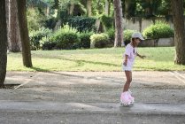 Petite fille avec tresses et chapeau roller dans le parc — Photo de stock