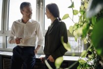 Geschäftsmann und Geschäftsfrau im Gespräch am Fenster — Stockfoto