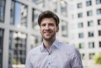 Retrato de homem de negócios sorridente andando na cidade — Fotografia de Stock