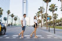 Giovane coppia attraversare strada in città e flirtare — Foto stock