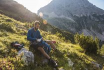 Austria, Tirolo, Escursionista seduto su una roccia in montagna — Foto stock