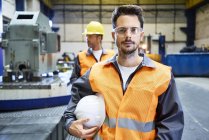 Portrait of serious man wearing protective workwear in factory — Stock Photo