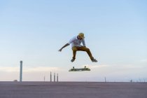 Young man doing a skateboard trick on a lane at dusk — Stock Photo