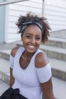 Positive Afroamerikanerin blickt in die Kamera und trägt Kopftuch — Stockfoto