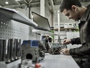 Arbeiter in der metallverarbeitenden Fabrik Messzylinderkopf mit Bremssattel — Stockfoto