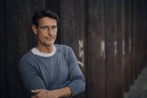 Uomo davanti alla parete metallica con le braccia incrociate, ritratto — Foto stock