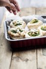 Woman Filled champignons with spinach and feta in gratin dish — Stock Photo