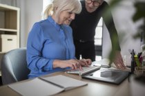 Dois colegas seniores trabalhando juntos na mesa no escritório — Fotografia de Stock
