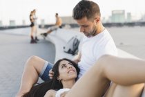 Felice giovane donna sdraiata sulle ginocchia del fidanzato in città — Foto stock