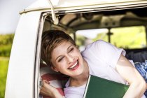 Glückliche Frau mit Buch im Lieferwagen — Stockfoto