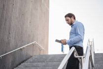 Geschäftsmann auf Treppe mit Tablet — Stockfoto