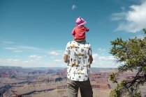 EUA, Arizona, Grand Canyon National Park, pai e bebê desfrutando da vista, carregando nos ombros, visão traseira — Fotografia de Stock
