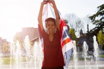 Portrait de jeune femme riante avec Union Jack près de la fontaine — Photo de stock