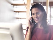 Portrait de femme d'affaires souriante au téléphone au bureau — Photo de stock