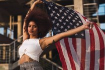Portrait of young woman waving American flag — Stock Photo