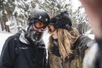 Селфи пары в лыжном костюме в зимнем лесу — стоковое фото