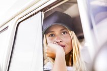 Junge Frau blickt aus dem Fenster eines Lieferwagens — Stockfoto
