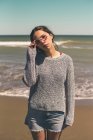 Espanha, retrato de uma jovem mulher usando óculos de sol em pé na praia — Fotografia de Stock