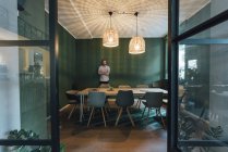 Homme seul dans le bureau de sa start-up, travaillant de longues heures — Photo de stock